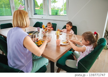 Family enjoying a meal together in a bright setting Family enjoying a meal together in a bright setting 139771747