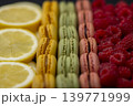 macaroons of different colors with raspberries and lemon 139771999