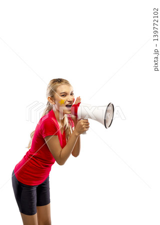 A young blonde Indonesian southeast asian woman in a red shirt celebrates, holding a megaphone with a clenched fist and face paint, isolated on a white background A young blonde Indonesian southeast asian woman in a red shirt celebrates, holding a megaphone with a clenched fist and face paint, isolated on a white background 139772102