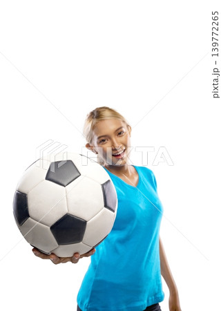 A beautiful young Indonesian southeast asian woman with blonde hair, wearing a blue t-shirt, poses while holding a classic black and white soccer ball near her face against a plain white background A beautiful young Indonesian southeast asian woman with blonde hair, wearing a blue t-shirt, poses while holding a classic black and white soccer ball near her face against a plain white background 139772265