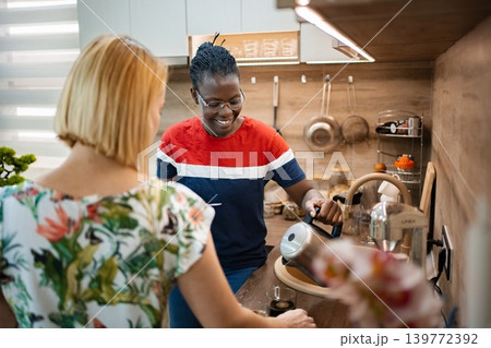 Preparing tea together in a cozy modern kitchen at sunset Preparing tea together in a cozy modern kitchen at sunset 139772392