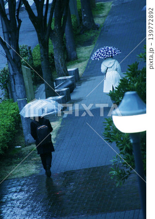 雨の早朝、駅に向かって歩く人 139772892