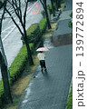 雨の朝、ピンクの傘の女性が駅に向かって歩いてゆく 139772894