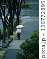 雨の朝、ピンクの傘の女性が駅に向かって 139772895