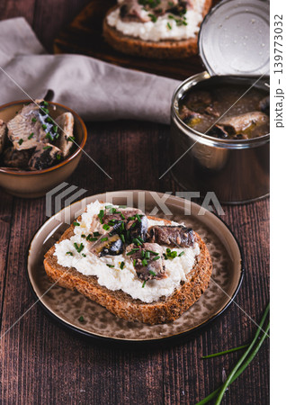 Open sandwiches with ricotta, sardines and chives on a plate on the table vertical view Open sandwiches with ricotta, sardines and chives on a plate on the table vertical view 139773032