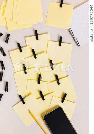 A pile of identical notepads, a smartphone, a notebook, and a pencil on the table top and vertical view A pile of identical notepads, a smartphone, a notebook, and a pencil on the table top and vertical view 139773044