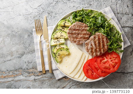 Low-carb diet burger plate with cheese, vegetables, herbs and beef patty close-up. Horizontal top view Low-carb diet burger plate with cheese, vegetables, herbs and beef patty close-up. Horizontal top view 139773110