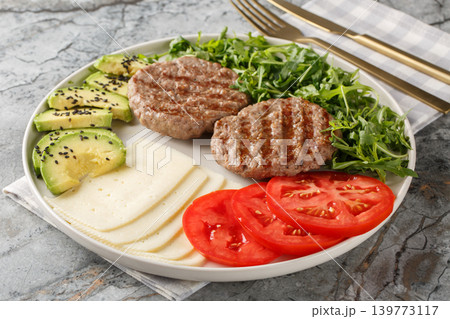 Low-carb diet burger plate with cheese, vegetables, herbs and beef patty close-up. Horizontal Low-carb diet burger plate with cheese, vegetables, herbs and beef patty close-up. Horizontal 139773117