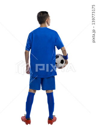 Back view of a Indonesian southeast asian soccer player in a blue uniform holding a ball under his arm, isolated on white. Perfect for sports marketing, fitness themes, and athletic concepts Back view of a Indonesian southeast asian soccer player in a blue uniform holding a ball under his arm, isolated on white. Perfect for sports marketing, fitness themes, and athletic concepts 139773175