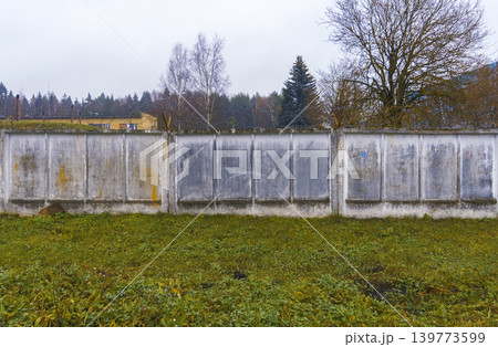 Stone fence landscape. Solid concrete boundary separating peaceful natural area from open countryside Stone fence landscape. Solid concrete boundary separating peaceful natural area from open countryside 139773599