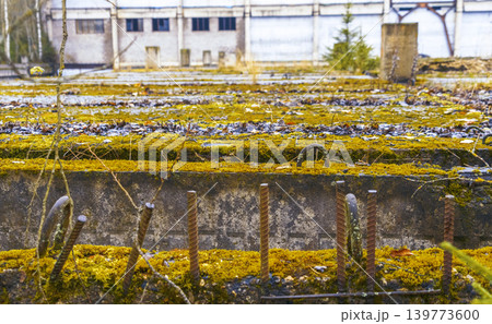 Surface featuring mosscovered concrete alongside aged stones and oxidized metallic components 139773600