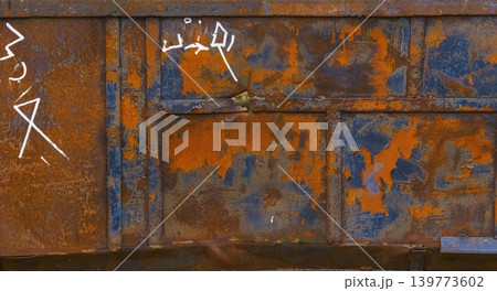 Corroded steel door with graffiti. Rusty metal panel showing peeling paint and rough texture Corroded steel door with graffiti. Rusty metal panel showing peeling paint and rough texture 139773602