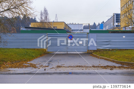 Quiet industrial area with fallen leaves. Corrugated front facing sidewalk covered in autumn leaves Quiet industrial area with fallen leaves. Corrugated front facing sidewalk covered in autumn leaves 139773614