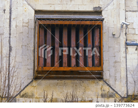 Closeup of neglected concrete with tarnished iron bars and peeling paint showing corrosion effects Closeup of neglected concrete with tarnished iron bars and peeling paint showing corrosion effects 139773624