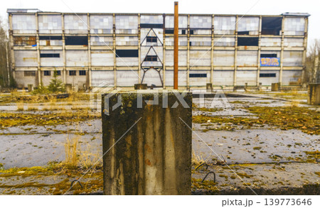 An individual standing alone on concrete structure amid abandoned surroundings and gloomy atmosphere An individual standing alone on concrete structure amid abandoned surroundings and gloomy atmosphere 139773646