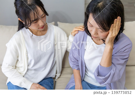 頭をおさえる母と心配する娘 頭をおさえる母と心配する娘 139773852