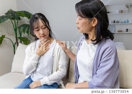 胸をおさえる娘と心配する母親 胸をおさえる娘と心配する母親 139773854