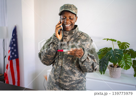 Excited african american soldier sharing pregnancy news on phone Excited african american soldier sharing pregnancy news on phone 139773979