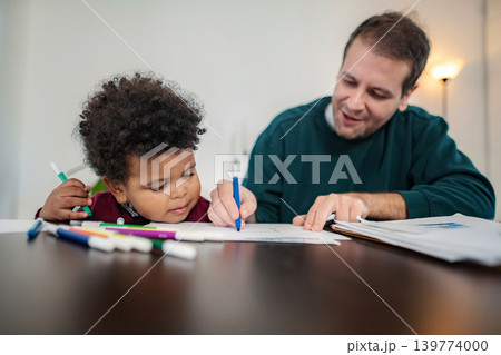 Father and son drawing together using markers at home 139774000