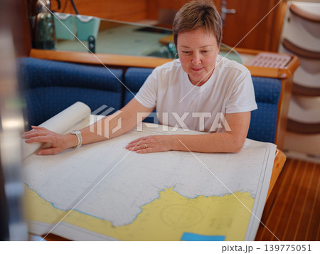 Woman Sailor Studying Navigation Map Inside Yacht Cabin Interior Woman Sailor Studying Navigation Map Inside Yacht Cabin Interior 139775051