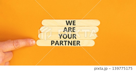 We are your partner symbol. Concept words We are your partner on beautiful wooden sticks. Beautiful orange background. Businessman hand. Business motivational we are your partner concept. Copy space. We are your partner symbol. Concept words We are your partner on beautiful wooden sticks. Beautiful orange background. Businessman hand. Business motivational we are your partner concept. Copy space. 139775175