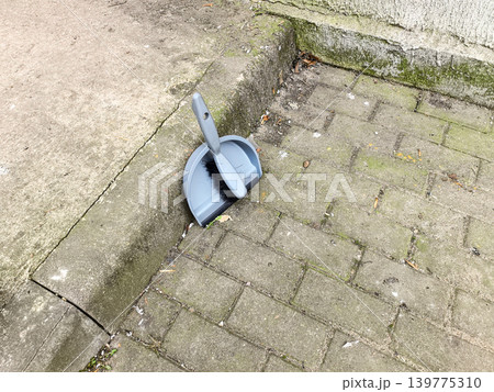 Grey Dustpan and Brush on Paving Stones Grey Dustpan and Brush on Paving Stones 139775310