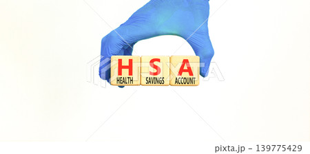 HSA health saving account symbol. Concept words HSA health saving account on beautiful wooden blocks. Beautiful white background. Doctor hand. Medical HSA health saving account concept. Copy space. HSA health saving account symbol. Concept words HSA health saving account on beautiful wooden blocks. Beautiful white background. Doctor hand. Medical HSA health saving account concept. Copy space. 139775429