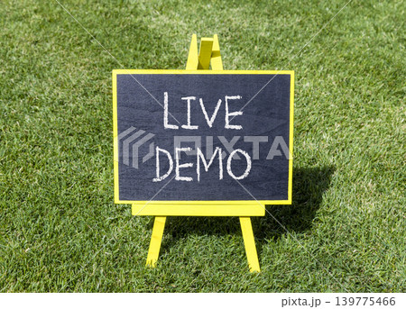 Live demo symbol. Concept words Live demo on beautiful black blackboard. Beautiful green grass lawn background. Copy space. Business and live demo concept. Live demo symbol. Concept words Live demo on beautiful black blackboard. Beautiful green grass lawn background. Copy space. Business and live demo concept. 139775466