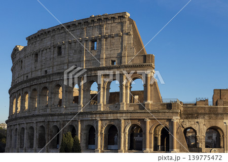 Famous Coliseum in Rome. Colosseum, or Coliseum. Sunset at huge Roman amphitheatre, Rome, Italy, Europe. Famous touristic place in the world and Europe. Beautiful blue sky background. 139775472