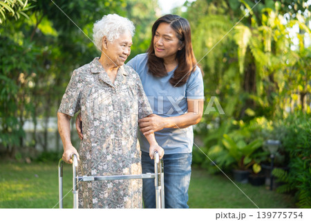 Asian elderly woman disability patient walk with walker in park, medical. Asian elderly woman disability patient walk with walker in park, medical. 139775754