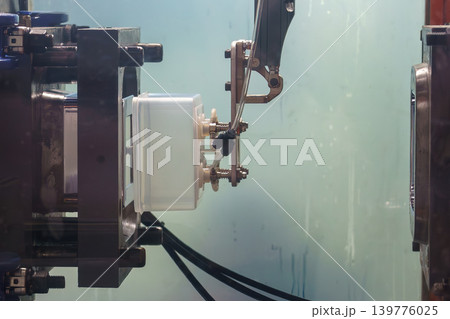 Automated robotic gripper performing material handling by extracting plastic injection parts from a molding machine. Automated robotic gripper performing material handling by extracting plastic injection parts from a molding machine. 139776025