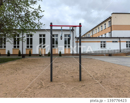 Outdoor gymnastics rings and pull up bar at school sports ground Outdoor gymnastics rings and pull up bar at school sports ground 139776423