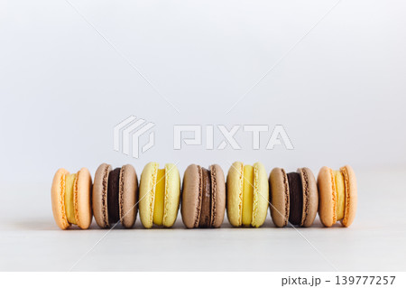 Set of French macarons on a white wooden table. Multicolored macarons. White background, pastel colors. Set of French macarons on a white wooden table. Multicolored macarons. White background, pastel colors. 139777257