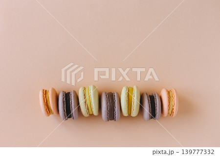 Tasty french macarons on a peach pastel background. Tasty french macarons on a peach pastel background. 139777332