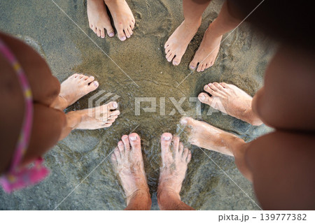Family feet standing in circle on Greece beach Family feet standing in circle on Greece beach 139777382