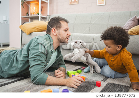 Multiracial family having fun in a cozy living room Multiracial family having fun in a cozy living room 139777672