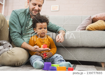Multiracial family playing with colorful building blocks at home Multiracial family playing with colorful building blocks at home 139777693