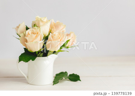 Romantic bouquet of pastel cream roses in a jar on a white background. Romantic bouquet of pastel cream roses in a jar on a white background. 139778139