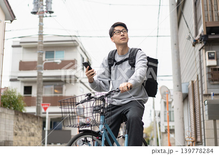 自転車で配達する男性 自転車で配達する男性 139778284