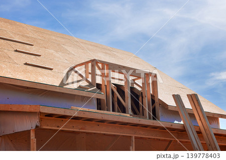 Workers are busy building new house roof, using wooden beams frames trusses roofing materials 139778403