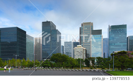 Tokyo, Japan - Oct 01 2024, A panoramic view of the Chiyoda district's skyscrapers on background of cloudy sky, with a parking lot in the foreground, at daytime, Tokyo, Japan Tokyo, Japan - Oct 01 2024, A panoramic view of the Chiyoda district's skyscrapers on background of cloudy sky, with a parking lot in the foreground, at daytime, Tokyo, Japan 139778553