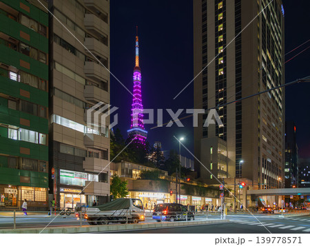 Tokyo, Japan - Oct 1 2024, panoramic view of skyscrapers with the Tokyo Tower illuminated in purple between them, with people walking in the foreground, at night with street lighting, Tokyo, Japan Tokyo, Japan - Oct 1 2024, panoramic view of skyscrapers with the Tokyo Tower illuminated in purple between them, with people walking in the foreground, at night with street lighting, Tokyo, Japan 139778571