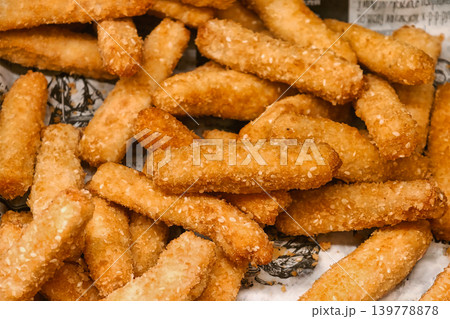 A basket holds many fried pieces that are golden brown and crispy, placed in a casual dining spot after sunset 139778878