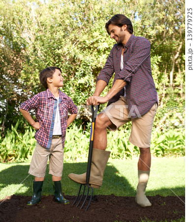 Child, father and smile with gardening in nature using tools for agriculture help and ecology education. Soil, bonding and a man teaching boy kid to plant with fork for organic earth growth Child, father and smile with gardening in nature using tools for agriculture help and ecology education. Soil, bonding and a man teaching boy kid to plant with fork for organic earth growth 139779725