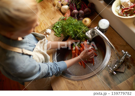 Person, sink and cleaning carrot in kitchen, health and hygiene with cooking food and top view. Vegetables, nutrition and organic for dinner meal, vegan or vegetarian with chef washing produce Person, sink and cleaning carrot in kitchen, health and hygiene with cooking food and top view. Vegetables, nutrition and organic for dinner meal, vegan or vegetarian with chef washing produce 139779782