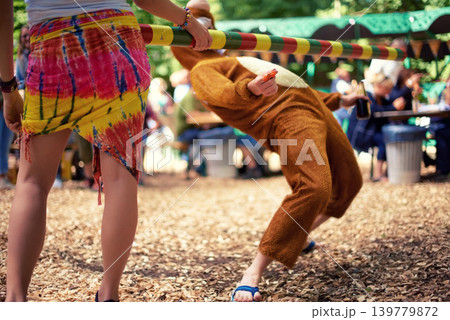 Limbo, game and person at party outdoor with balance and playing at a music festival, event or challenge. Fun, people and outdoor in woods, forest or person in social activity at party in bear suit Limbo, game and person at party outdoor with balance and playing at a music festival, event or challenge. Fun, people and outdoor in woods, forest or person in social activity at party in bear suit 139779872