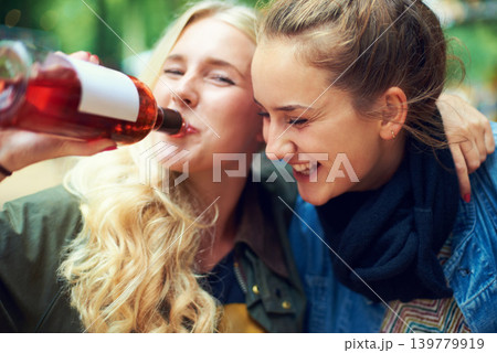 Portrait, concert and women with a bottle of wine, hug and smile with happiness or bonding together. Funny, people or outdoor with friends or alcohol with weekend break or excited with music festival Portrait, concert and women with a bottle of wine, hug and smile with happiness or bonding together. Funny, people or outdoor with friends or alcohol with weekend break or excited with music festival 139779919