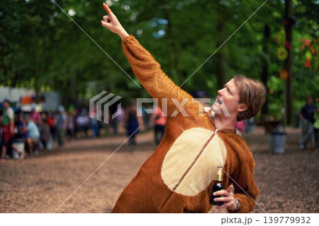 Halloween, costume and man with beer to drink at happy celebration outdoor in bear outfit. Animal, suit and person pointing to trees with lager, bottle and drinking alcohol in park at festival Halloween, costume and man with beer to drink at happy celebration outdoor in bear outfit. Animal, suit and person pointing to trees with lager, bottle and drinking alcohol in park at festival 139779932