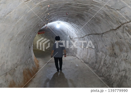 Person Walking Through Concrete Tunnel Person Walking Through Concrete Tunnel 139779990