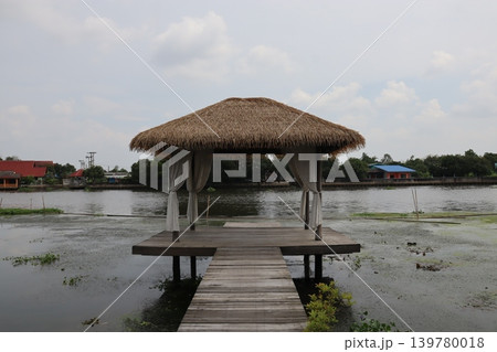 Thatched Hut Over Water with Wooden Dock 139780018